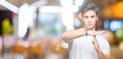 Young handsome man wearing white t-shirt over isolated background Doing time out gesture with hands, frustrated and serious face