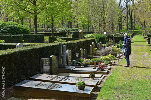 A woman visits a gravesite in a cemetery near Oosterbeek, Netherlands photo