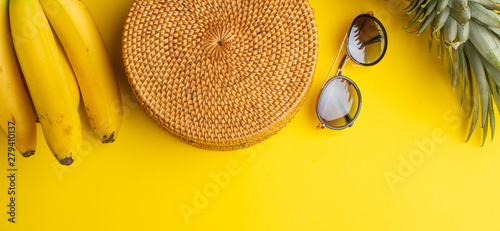 Summer colorful background with wicker fashion bag, women's shoes and tropical pineapple, bananas and sun fashion glasses. Summer fashion, holiday concept.Flat lay Banner