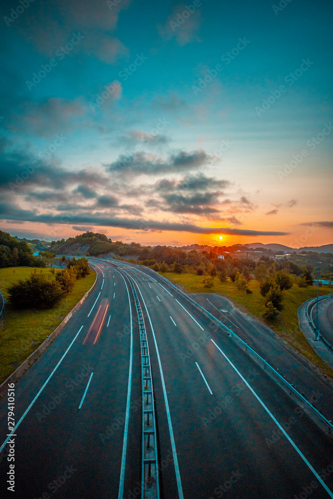 Sunset on a road, enter the clouds to cover the sun and take an orange color. Vertical photo, Basque Country Sunset on a road, enter the clouds to cover the sun and take an orange color. Vertical photo, Basque Country