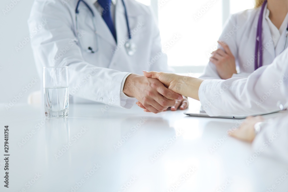 Doctor shaking hands with a male patient in the office Doctor shaking hands with a male patient in the office