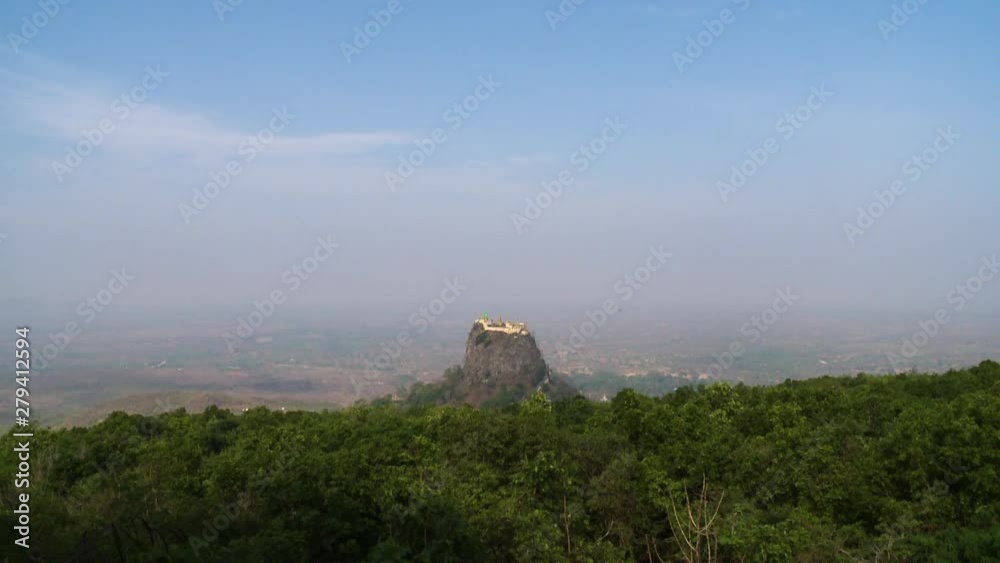 A steady, long shot of a fortress built on the top of a stone rock, above a beautiful green forest in a summer day. A steady, long shot of a fortress built on the top of a stone rock, above a beautiful green forest in a summer day.