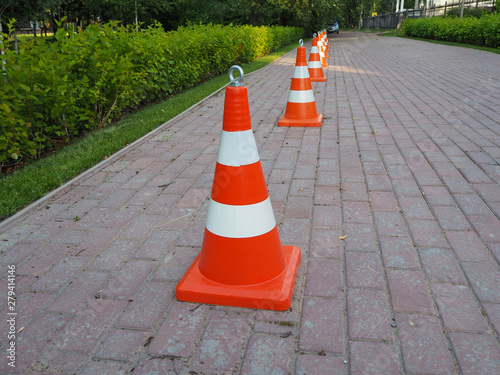 Orange and white striped traffic cones chained together. It is used as a fence when carrying out road-building works, for demarcating traffic or for designating emergency sites and road accidents.