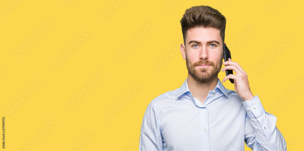Young handsome man business talking on smartphone with a confident expression on smart face thinking serious Young handsome man business talking on smartphone with a confident expression on smart face thinking serious