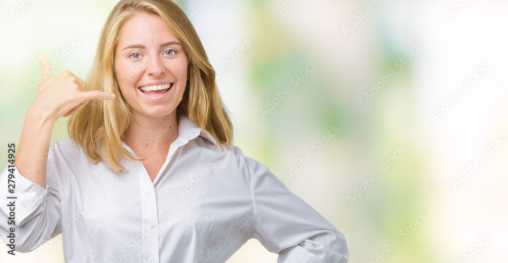 Beautiful young business woman over isolated background smiling doing phone gesture with hand and fingers like talking on the telephone. Communicating concepts.