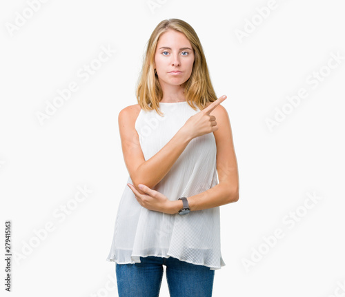 Beautiful young elegant woman over isolated background Pointing with hand finger to the side showing advertisement, serious and calm face