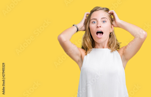 Beautiful young elegant woman over isolated background Crazy and scared with hands on head, afraid and surprised of shock with open mouth