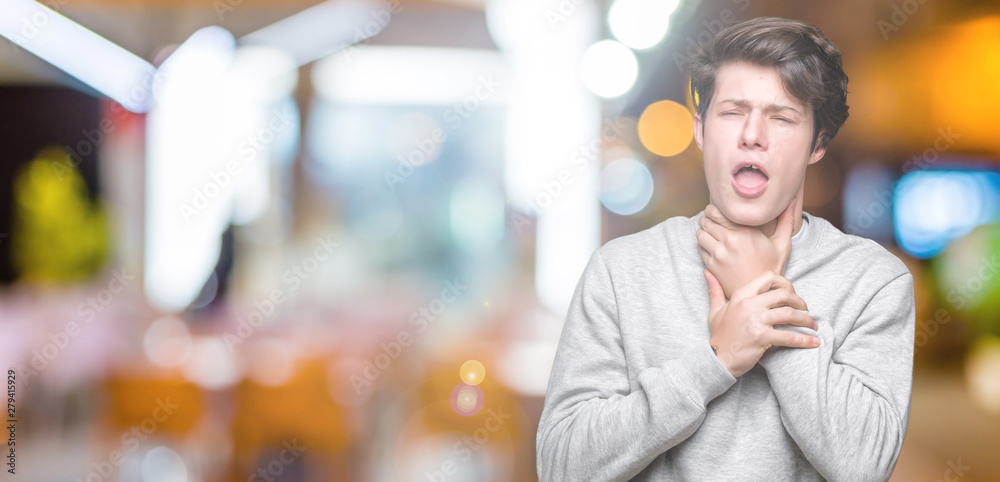 Naklejka premium Young handsome sporty man wearing sweatshirt over isolated background shouting and suffocate because painful strangle. Health problem. Asphyxiate and suicide concept.