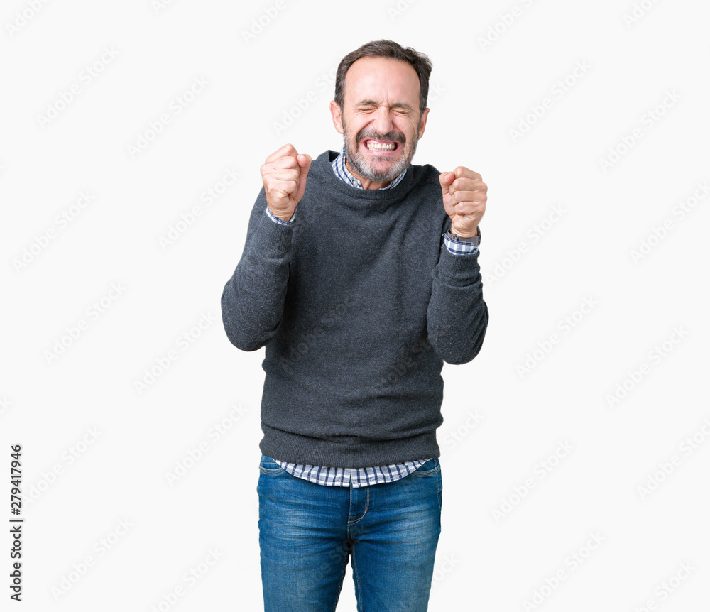 Fototapeta premium Handsome middle age senior man wearing a sweater over isolated background excited for success with arms raised celebrating victory smiling. Winner concept.