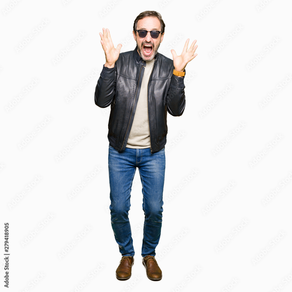 Middle age handsome man wearing sunglasses and black leather jacket celebrating crazy and amazed for success with arms raised and open eyes screaming excited. Winner concept Middle age handsome man wearing sunglasses and black leather jacket celebrating crazy and amazed for success with arms raised and open eyes screaming excited. Winner concept