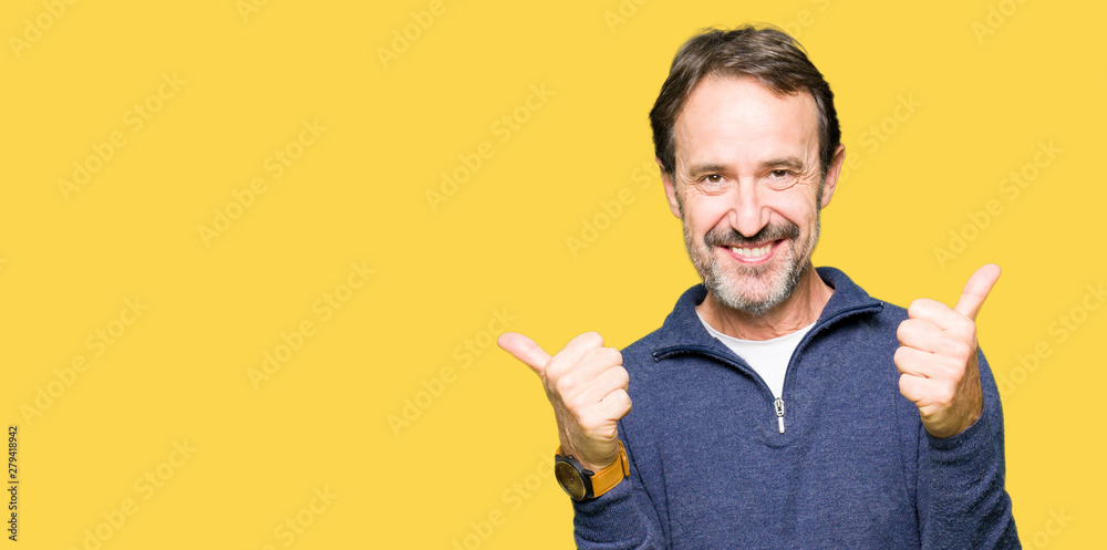 Middle age handsome man wearing a sweater success sign doing positive gesture with hand, thumbs up smiling and happy. Looking at the camera with cheerful expression, winner gesture. Middle age handsome man wearing a sweater success sign doing positive gesture with hand, thumbs up smiling and happy. Looking at the camera with cheerful expression, winner gesture.