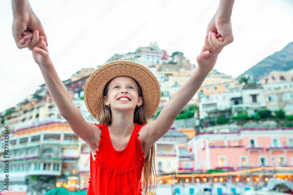 Adorable little girl on warm and sunny summer day in Positano town in Italy