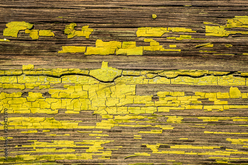 Vivid yellow cracked paint on wooden planks background texture overlay