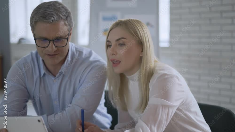 Smiling business team discussing over digital tablet in office 4K Smiling business team discussing over digital tablet in office 4K