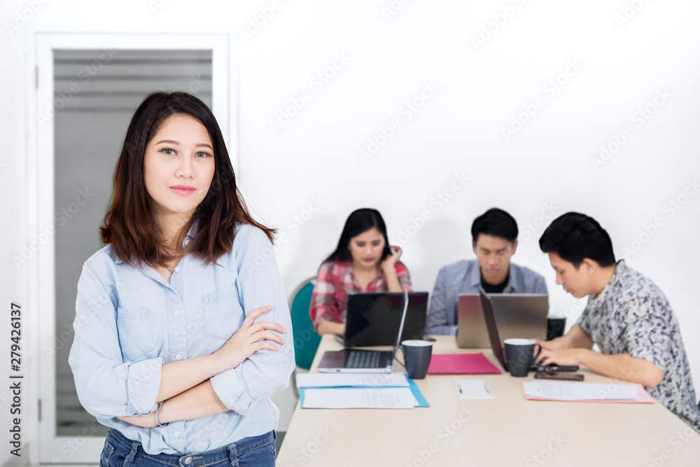 Confident female entrepreneur near her business team Confident female entrepreneur near her business team