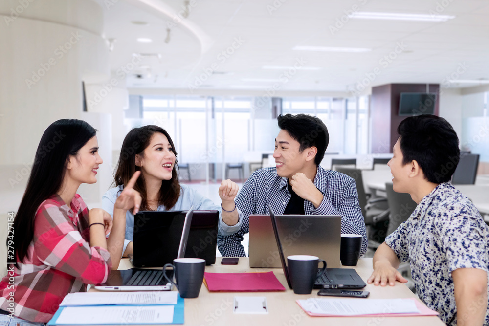 Happy business team discussing project in the office Happy business team discussing project in the office