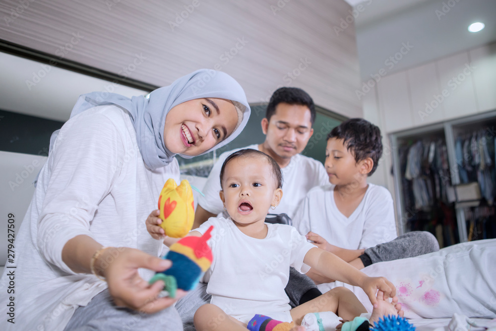 Muslim family enjoying leisure time on the bed Muslim family enjoying leisure time on the bed