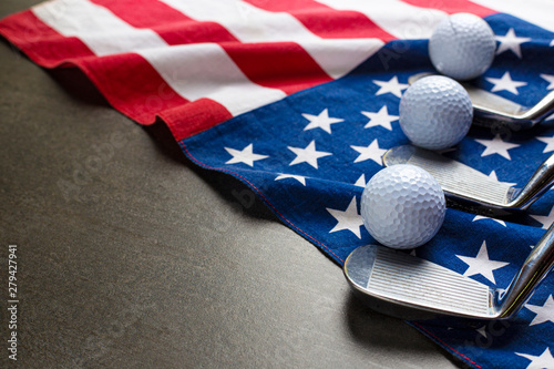 Golf ball and golf club with flag of USA on wood black table background