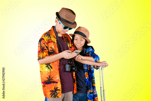 Two child tourists using a phone on studio