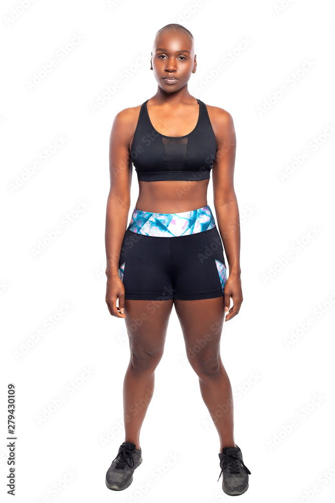 Athletic African American black female wearing workout clothing. Her sporty  outfit is a sports bra and form fitting spandex shorts. She looks strong  and confident. Stock Photo