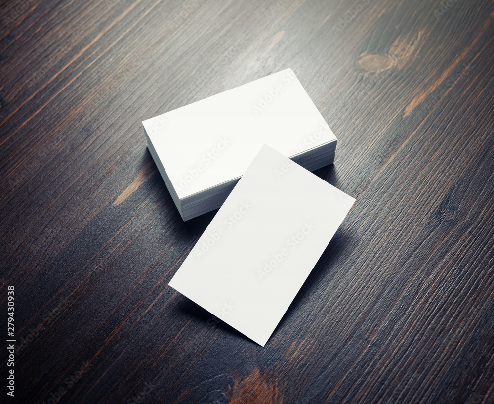 Blank white paper business cards on dark wood table background. Copy space for text. Blank white paper business cards on dark wood table background. Copy space for text.