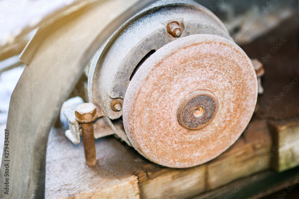A machine for turning a round shape. Grinder. Old and rusty grinding whetstone tool. Workplace worker. A machine for turning a round shape. Grinder. Old and rusty grinding whetstone tool. Workplace worker.