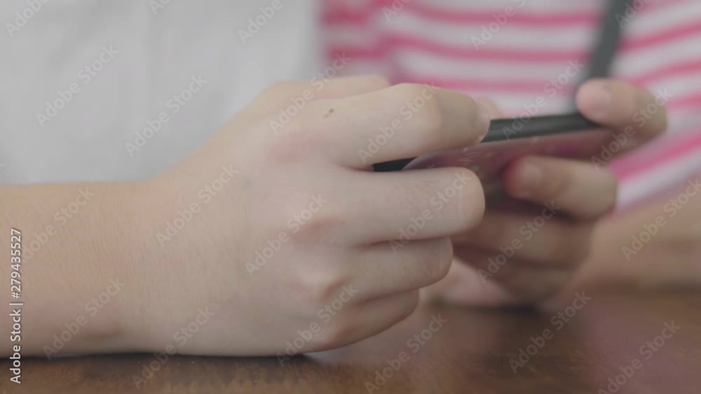 Close up hand of asian boy using on mobile smart phone.