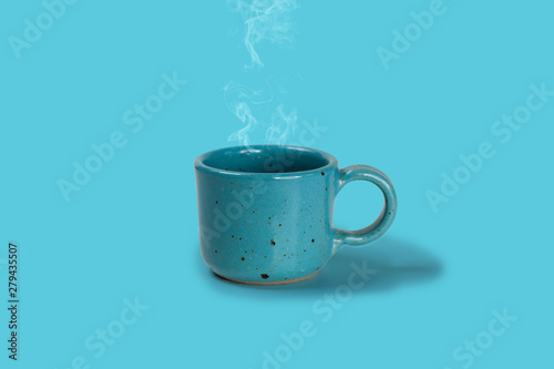 A blue cups with fresh coffee on blue background.