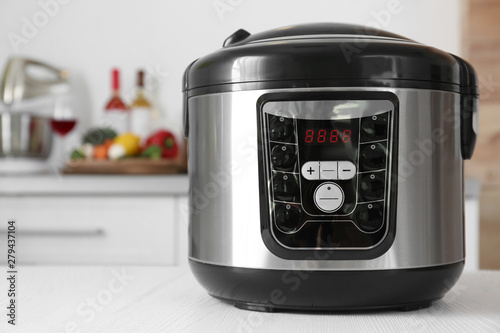 Modern multi cooker on table in kitchen. Space for text