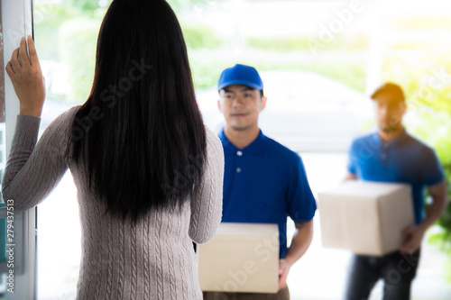 Woman customer signing receipt and receiving the parcel from delivery man. Business and logistic concept. photo