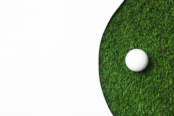Golf ball and white paper on green artificial grass, top view with space for text