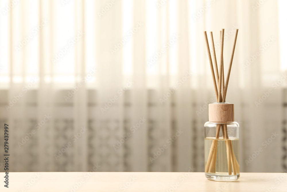 Reed air freshener on table indoors, space for text