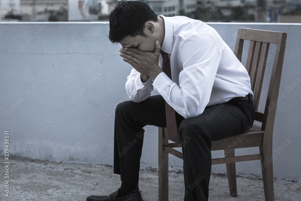 Stressed sad young business man sitting outside on bench. Stressed sad young business man sitting outside on bench.