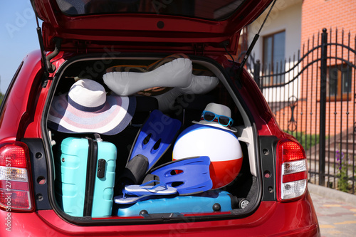Fototapeta Naklejka Na Ścianę i Meble -  Family car with open trunk full of luggage outdoors, closeup