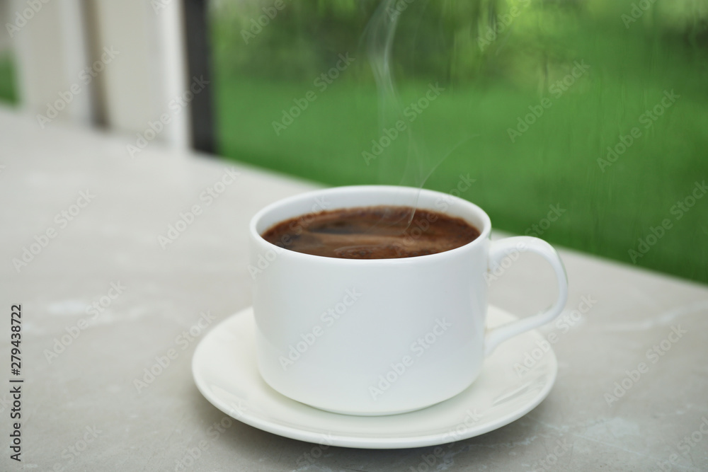 Cup of hot aromatic coffee on white wooden windowsill. Rainy weather Cup of hot aromatic coffee on white wooden windowsill. Rainy weather