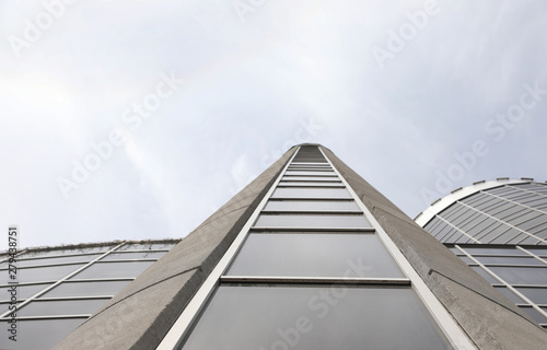 Modern building with tinted windows against sky, low angle view. Urban architecture