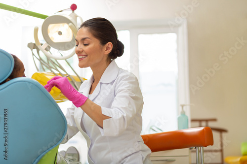 Fototapeta Naklejka Na Ścianę i Meble -  Middle-aged Caucasian female dentist performing a dental exam