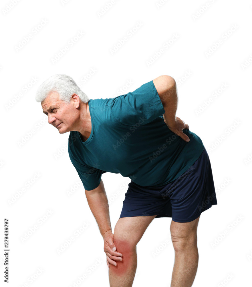 Portrait of senior man having knee problems on grey background Portrait of senior man having knee problems on grey background
