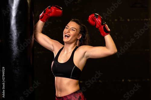Strong woman with boxing gloves on hands exercise on gym