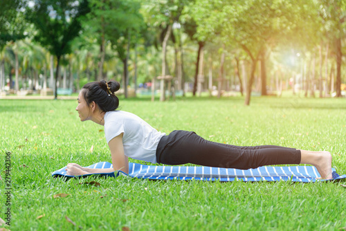 Young Asian woman practicing yoga pose at the park , Photo concept for Yoga Sport and Healthy lifestyle.