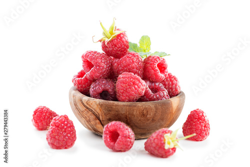 Fresh raspberry in a wooden plate isolated on white background.