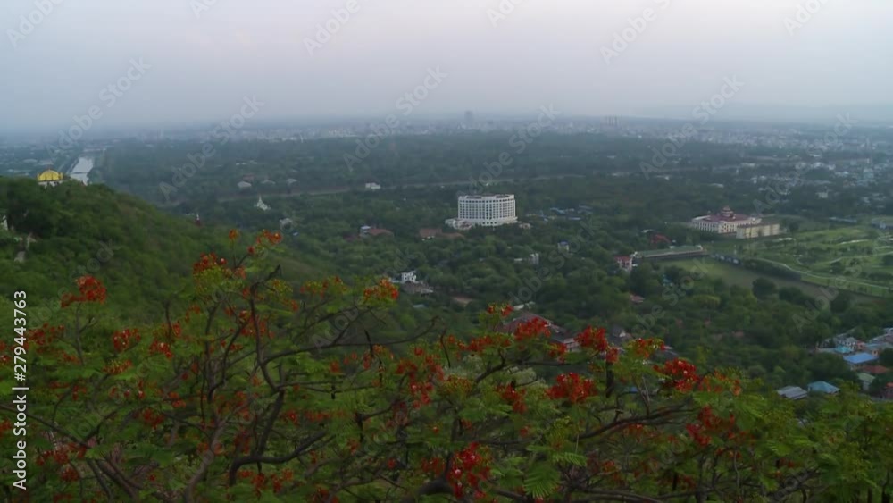 A bird's eye view of green vegetation around a few buildings in a part of a city in Myanmar A bird's eye view of green vegetation around a few buildings in a part of a city in Myanmar