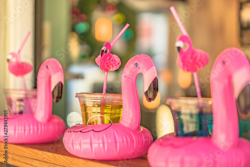 Cocktail glass with a flamingo-shaped straw and buoy aligned on a bar counter in Mihama Town Resort American Village photo