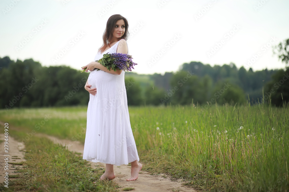Pregnant woman in nature for a walk in the summer
