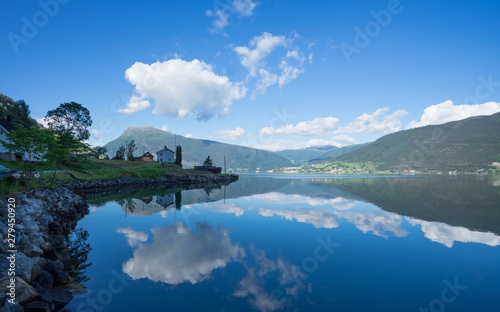 Panoramic view of The Sognefjord  Sognefjorden   nicknamed the King of the Fjords. Te largest and deepest fjord in Norway. Symmetry created by reflections in the still ocean water. Bright midsummer.