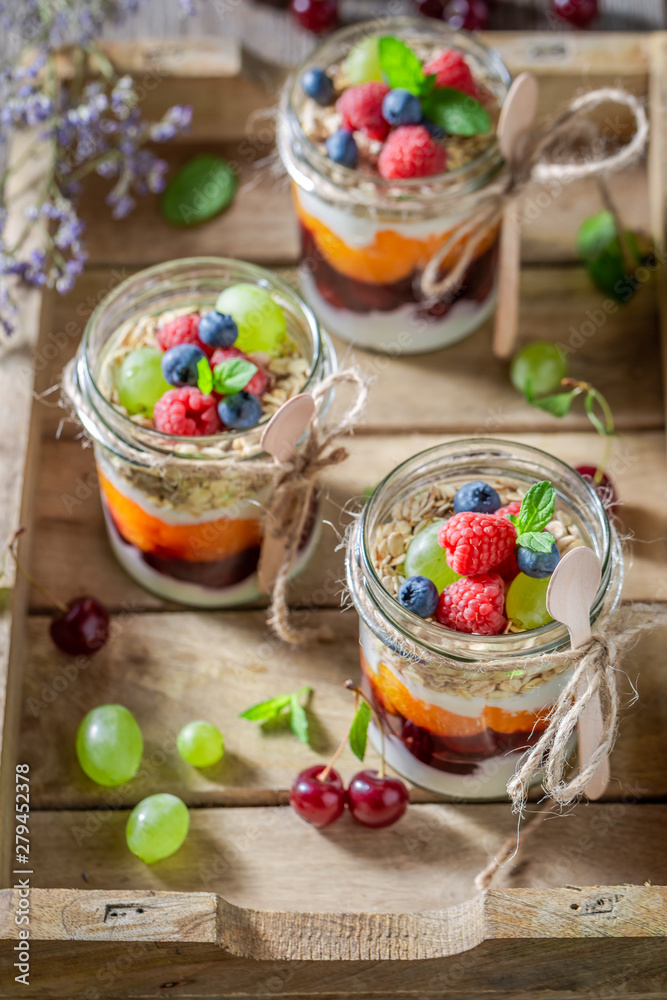 Homemade granola with fresh berries and yoghurt in jar