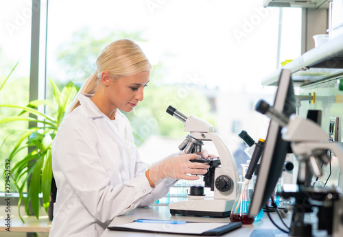 Scientist working in lab. Female doctor making medical research. Laboratory tools: microscope, test tubes, equipment. Biotechnology, chemistry, science, experiments and healthcare.