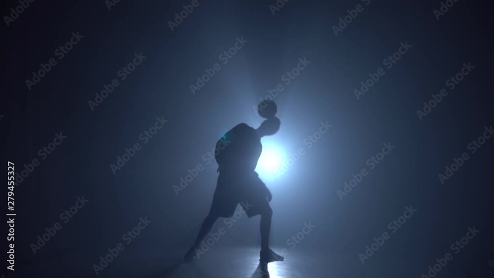 Athlete showing tricks with ball while holding it on head. Athlete showing tricks with ball while holding it on head.