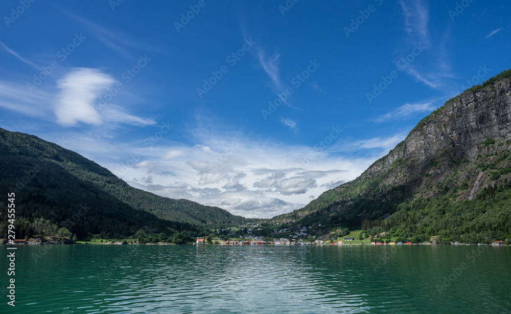 Panoramic view from the fjord at Solvorn, a cute small resort village pressed between mountains on the western shore of the Lustrafjorden (innermost part of the Sognefjorden). Midsummer day in Norway.