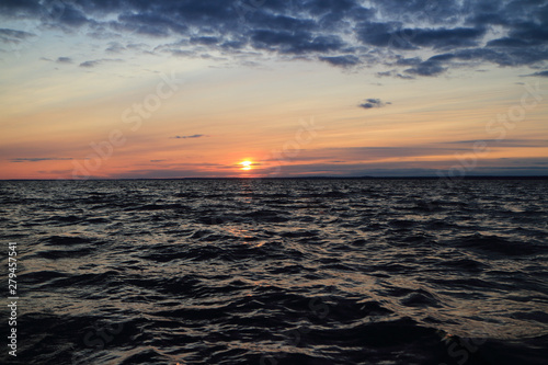 harsh sea in the evening at sunset, dramatic seascape setting sun red horizon © mrivserg